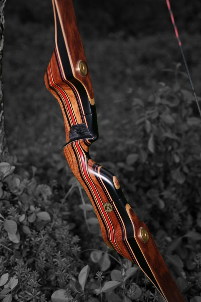 a-wooden-bow-hanging-from-the-side-of-a-tree-jwwhg8xxn2m